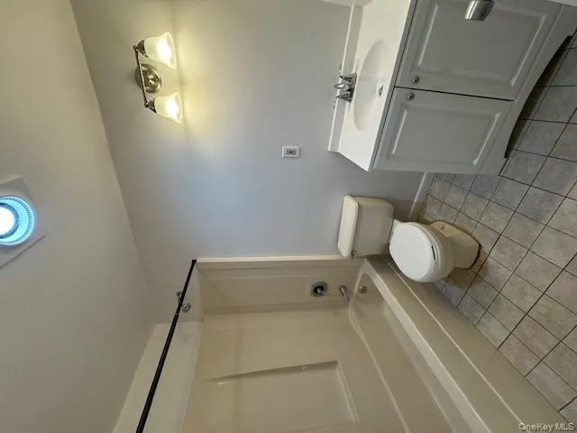 Bathroom with vanity, washtub / shower combination, and light tile patterned flooring Bathroom with vanity, washtub / shower combination, and light tile patterned flooring