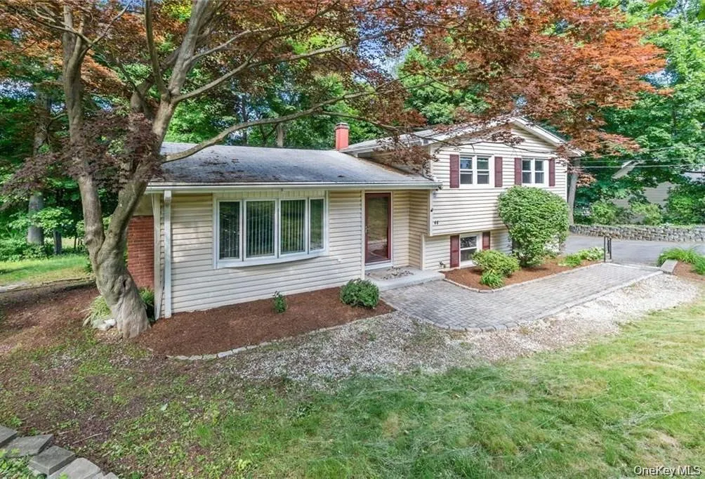 Split level home featuring a front lawn Split level home featuring a front lawn