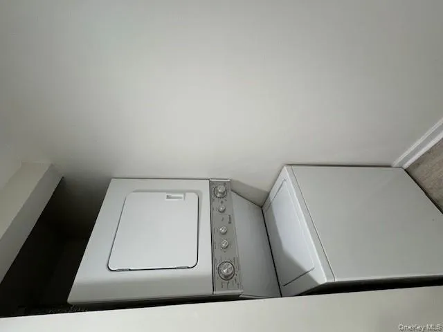 Laundry area with estacked washer and dryer and baseboards Laundry area with estacked washer and dryer and baseboards