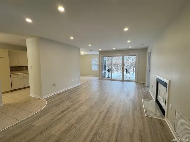 Unfurnished living room featuring recessed lighting, light wood-style floors, and a fireplace Unfurnished living room featuring recessed lighting, light wood-style floors, and a fireplace