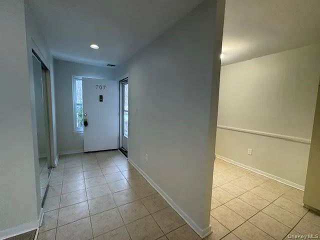 Foyer entrance featuring light tile patterned floors and a textured ceiling Foyer entrance featuring light tile patterned floors and a textured ceiling