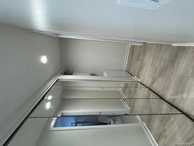 Corridor featuring stacked washer / dryer, light wood finished floors, and recessed lighting Corridor featuring stacked washer / dryer, light wood finished floors, and recessed lighting