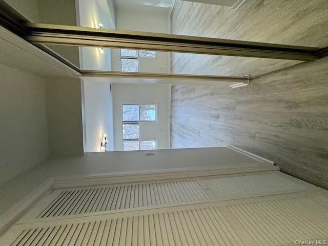 Hall with light wood-style flooring and a textured ceiling Hall with light wood-style flooring and a textured ceiling