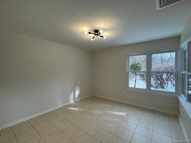 Spare room with baseboards and light tile patterned floors Spare room with baseboards and light tile patterned floors