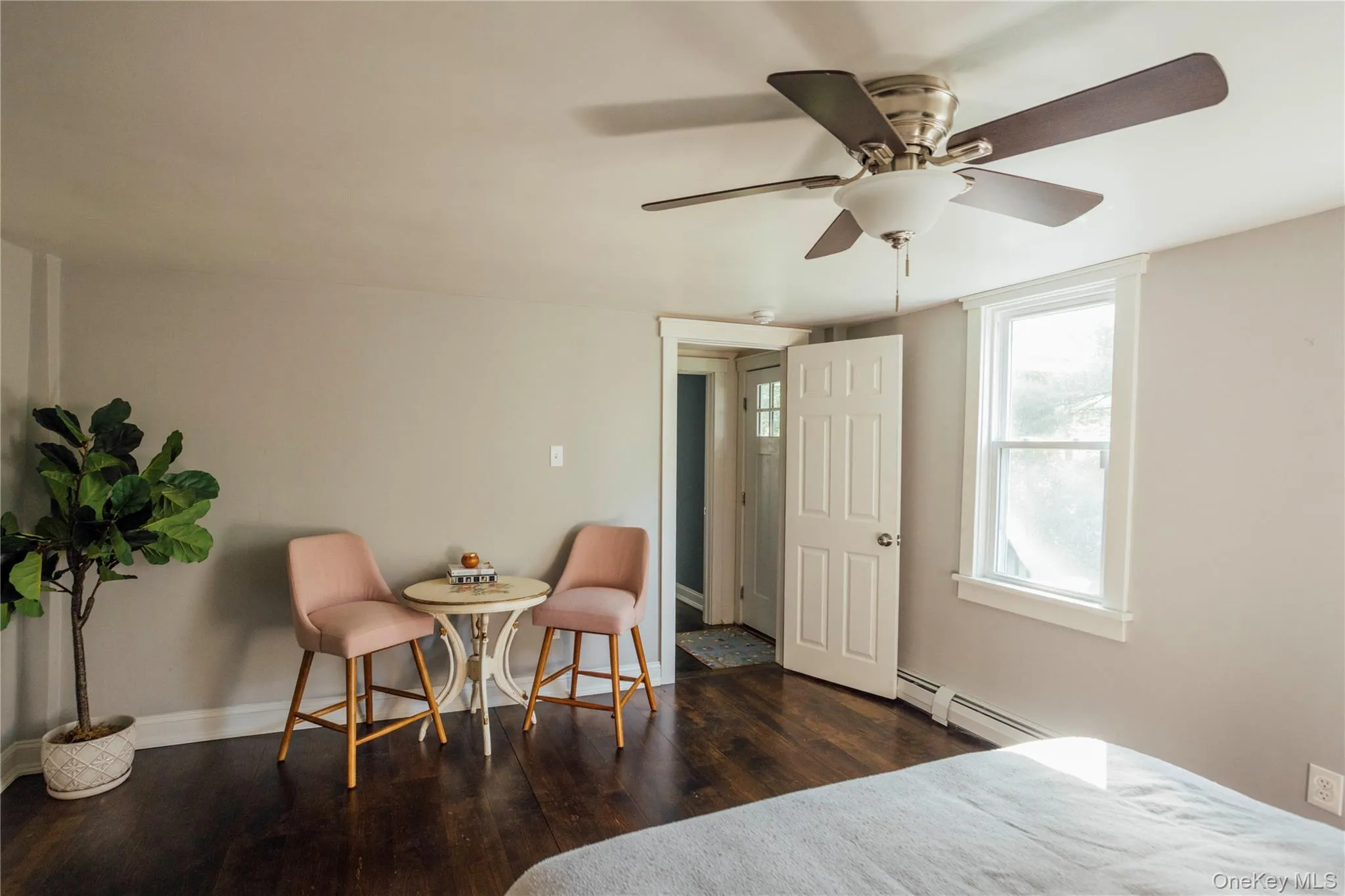 Bedroom with wood finished floors, a baseboard heating unit, and ceiling fan Bedroom with wood finished floors, a baseboard heating unit, and ceiling fan