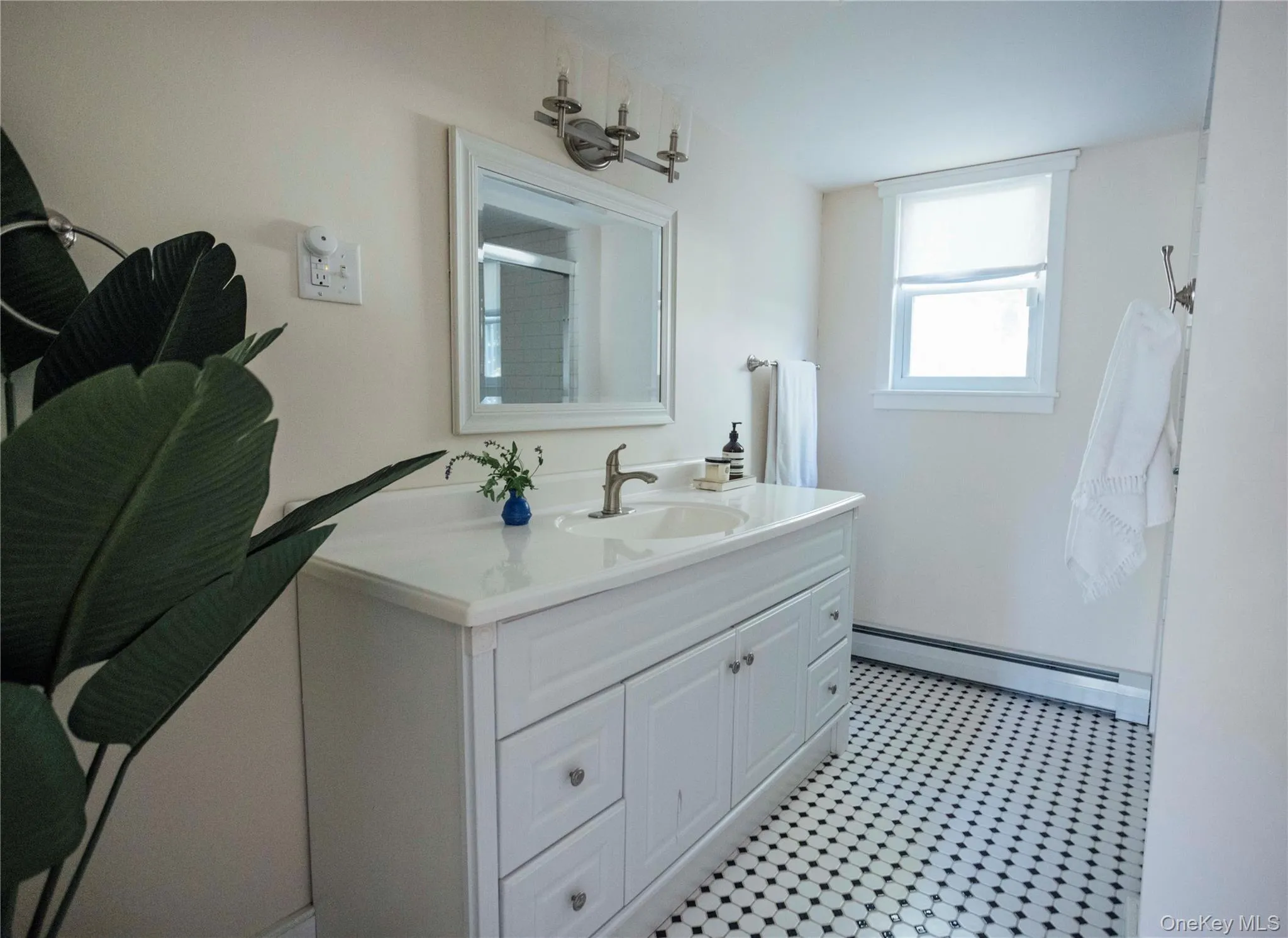 Bathroom featuring a baseboard heating unit and vanity Bathroom featuring a baseboard heating unit and vanity