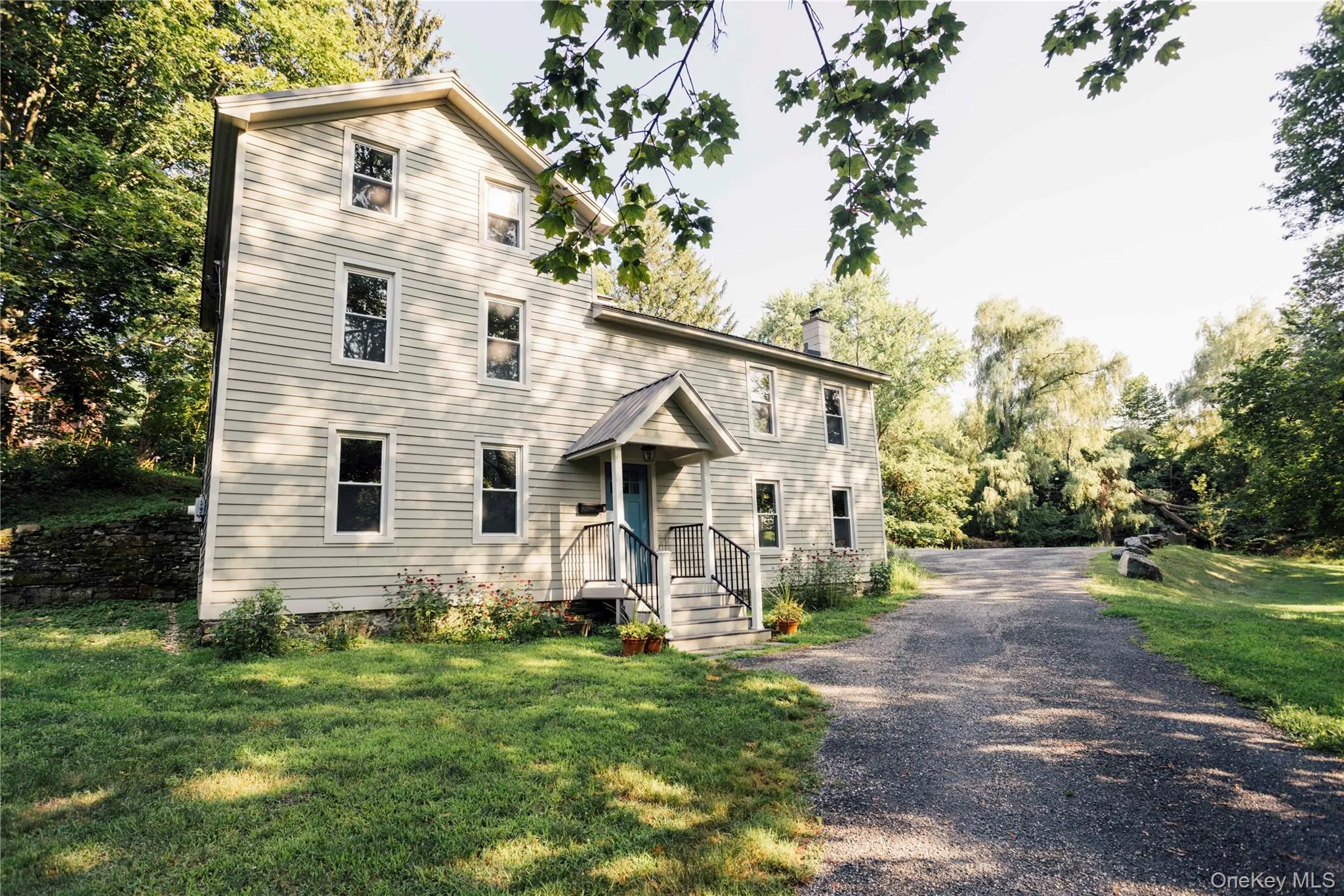 View of front of home featuring a chimney, a front yard, and gravel driveway View of front of home featuring a chimney, a front yard, and gravel driveway