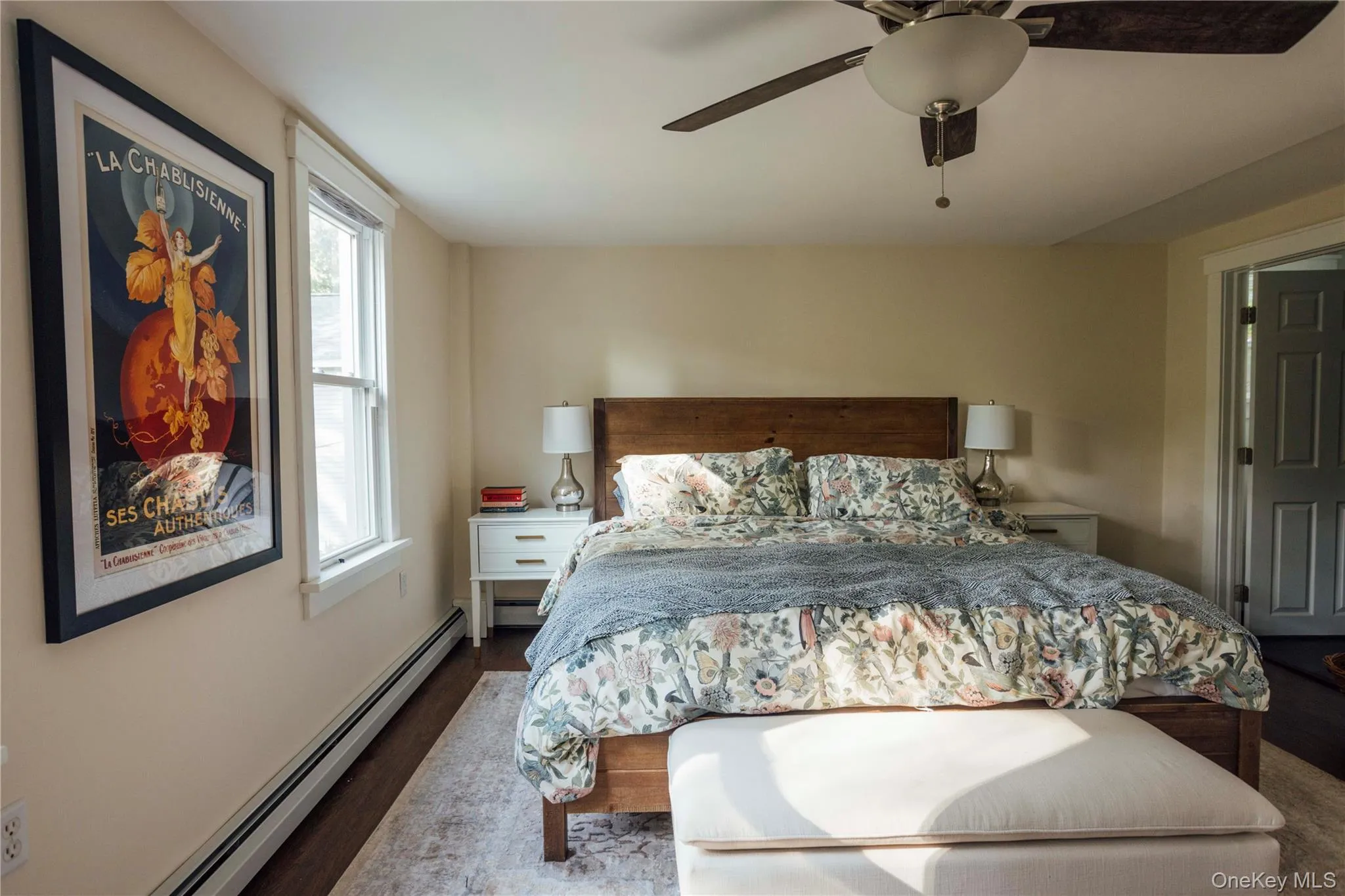 Bedroom featuring a baseboard heating unit, dark wood-style floors, and ceiling fan Bedroom featuring a baseboard heating unit, dark wood-style floors, and ceiling fan