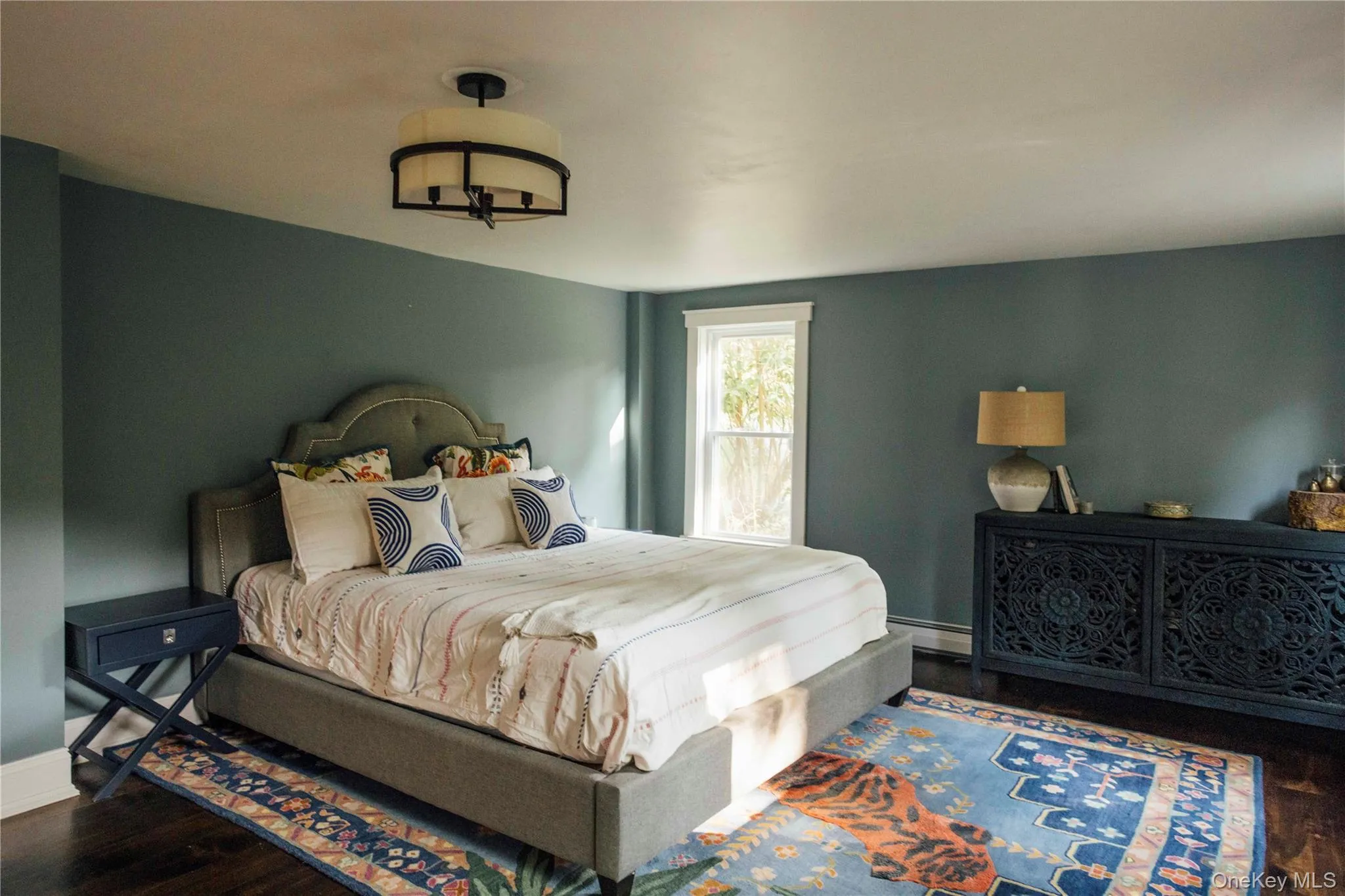 Bedroom featuring wood finished floors and baseboard heating Bedroom featuring wood finished floors and baseboard heating
