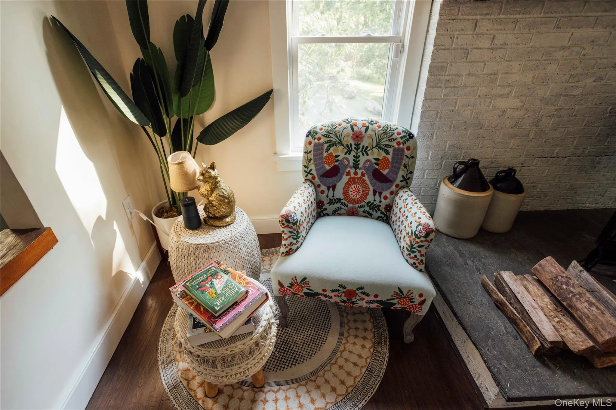Living area featuring wood finished floors and brick wall Living area featuring wood finished floors and brick wall