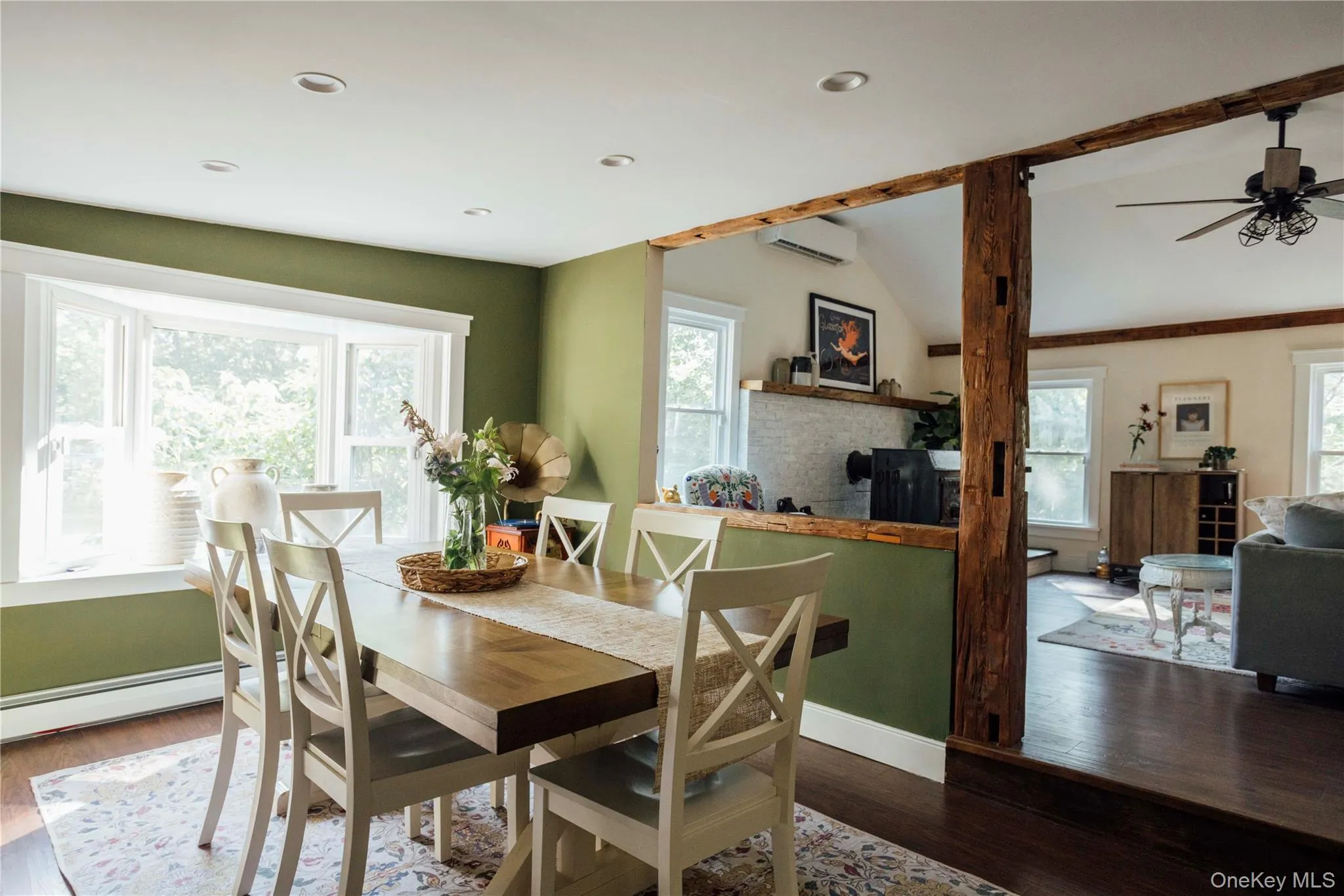 Dining area featuring wood finished floors, a ceiling fan, a brick fireplace, recessed lighting, and a baseboard radiator Dining area featuring wood finished floors, a ceiling fan, a brick fireplace, recessed lighting, and a baseboard radiator