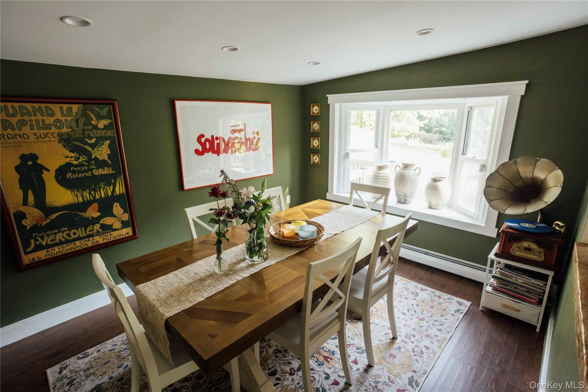 Dining room featuring dark wood finished floors and a baseboard radiator Dining room featuring dark wood finished floors and a baseboard radiator