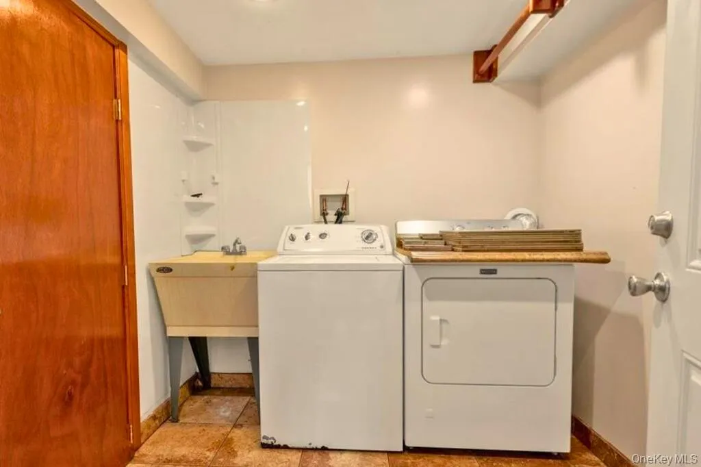 Laundry room with washing machine and clothes dryer and baseboards Laundry room with washing machine and clothes dryer and baseboards