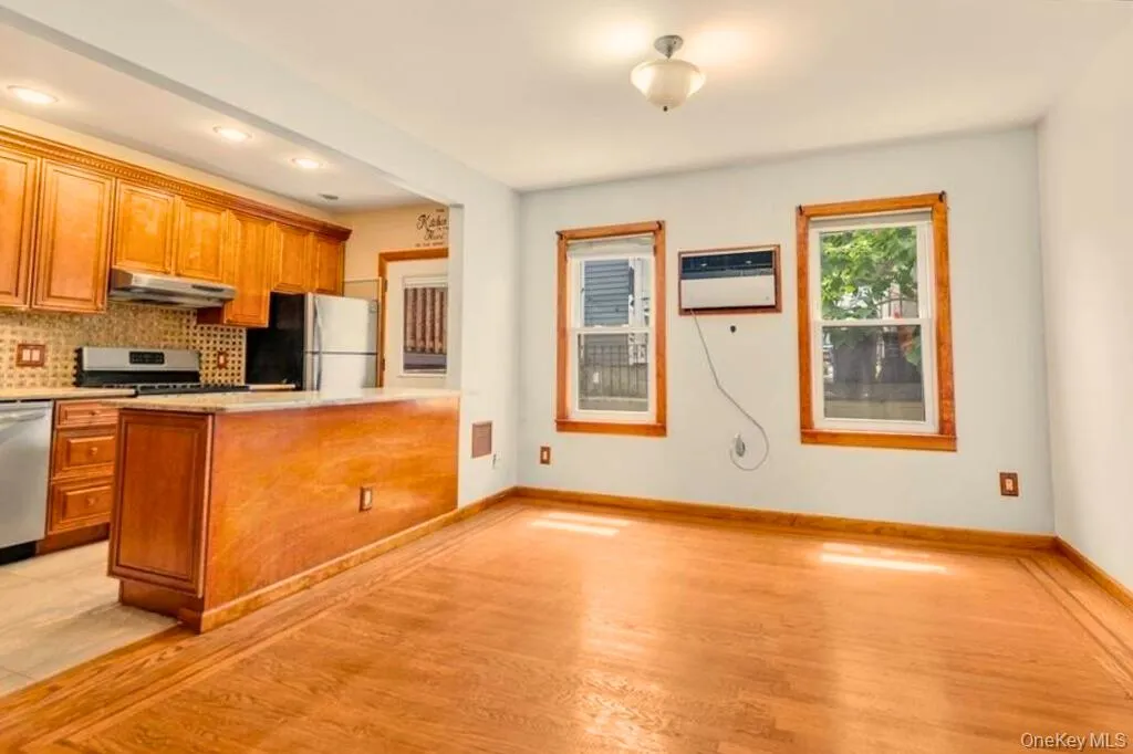 Kitchen featuring brown cabinetry, backsplash, light wood finished floors, stainless steel appliances, and recessed lighting Kitchen featuring brown cabinetry, backsplash, light wood finished floors, stainless steel appliances, and recessed lighting
