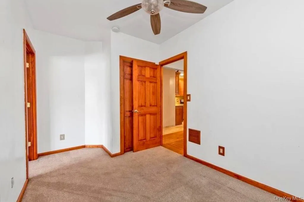 Unfurnished bedroom featuring light colored carpet and ceiling fan Unfurnished bedroom featuring light colored carpet and ceiling fan