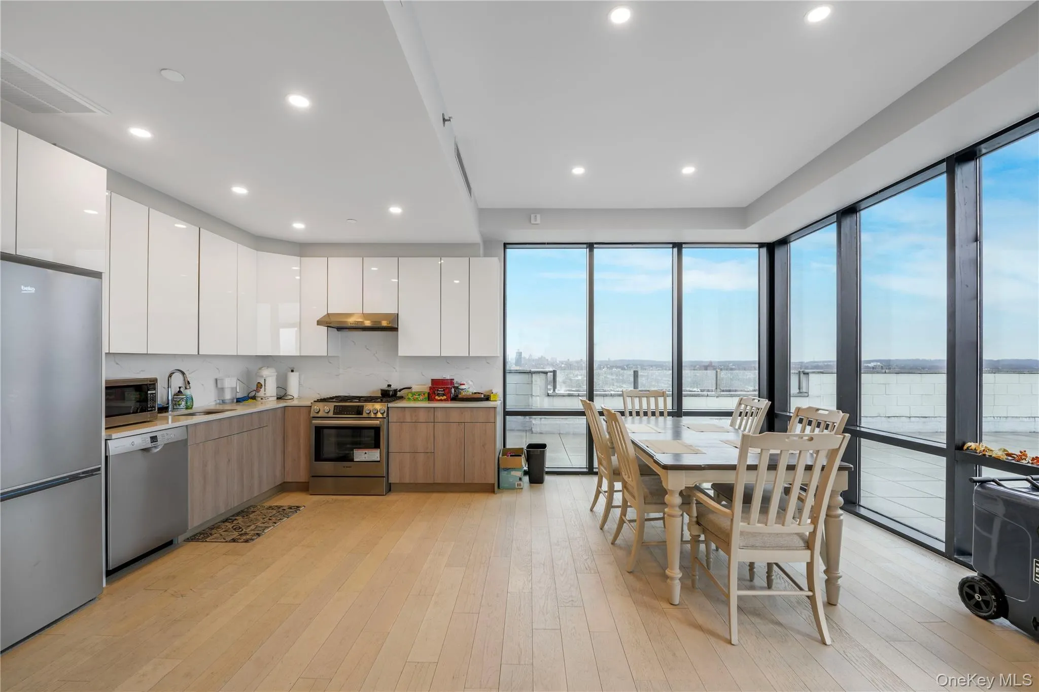 Kitchen with modern cabinets, white cabinetry, appliances with stainless steel finishes, and recessed lighting Kitchen with modern cabinets, white cabinetry, appliances with stainless steel finishes, and recessed lighting
