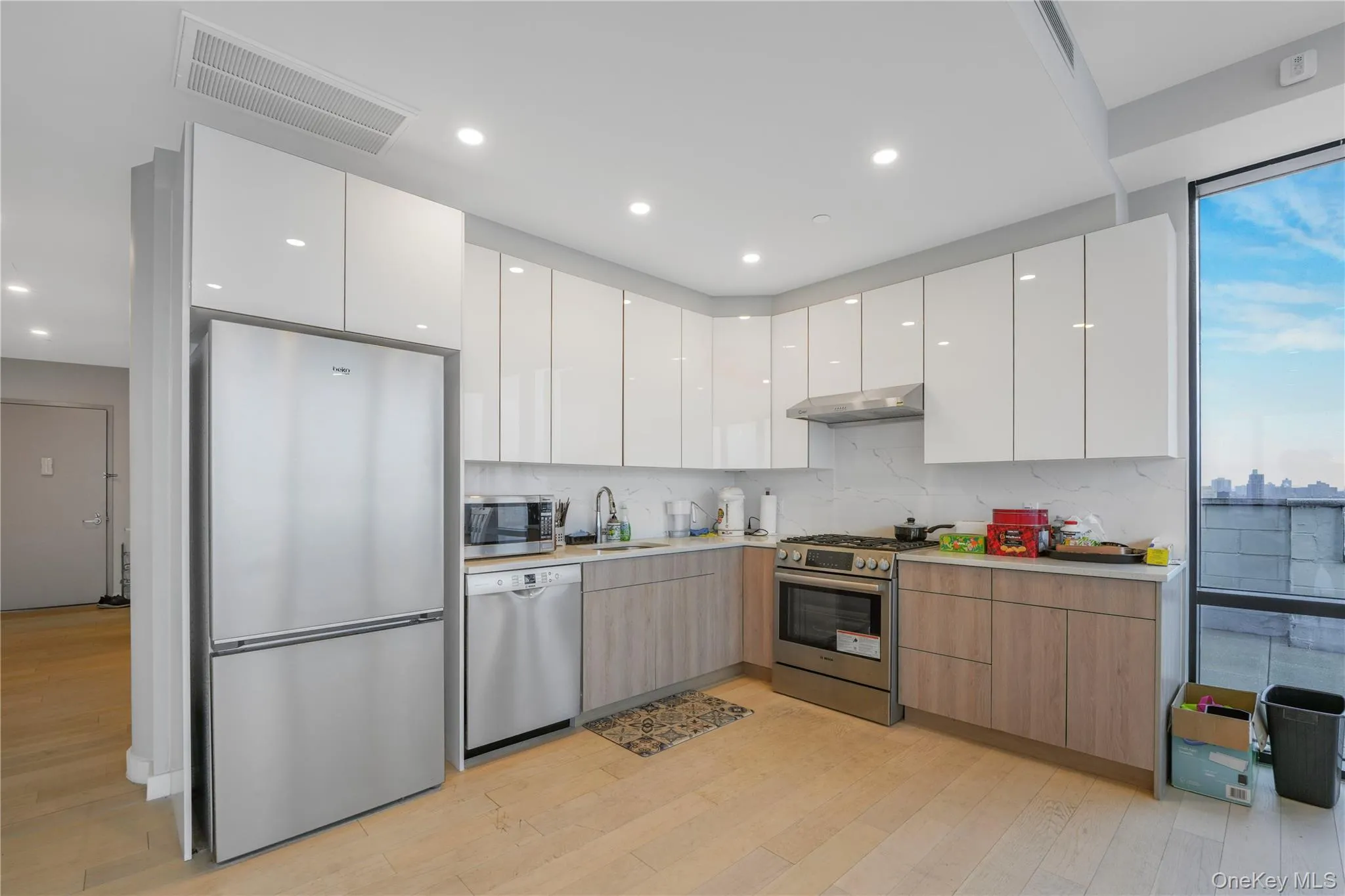 Kitchen featuring white cabinetry, modern cabinets, stainless steel appliances, and recessed lighting Kitchen featuring white cabinetry, modern cabinets, stainless steel appliances, and recessed lighting