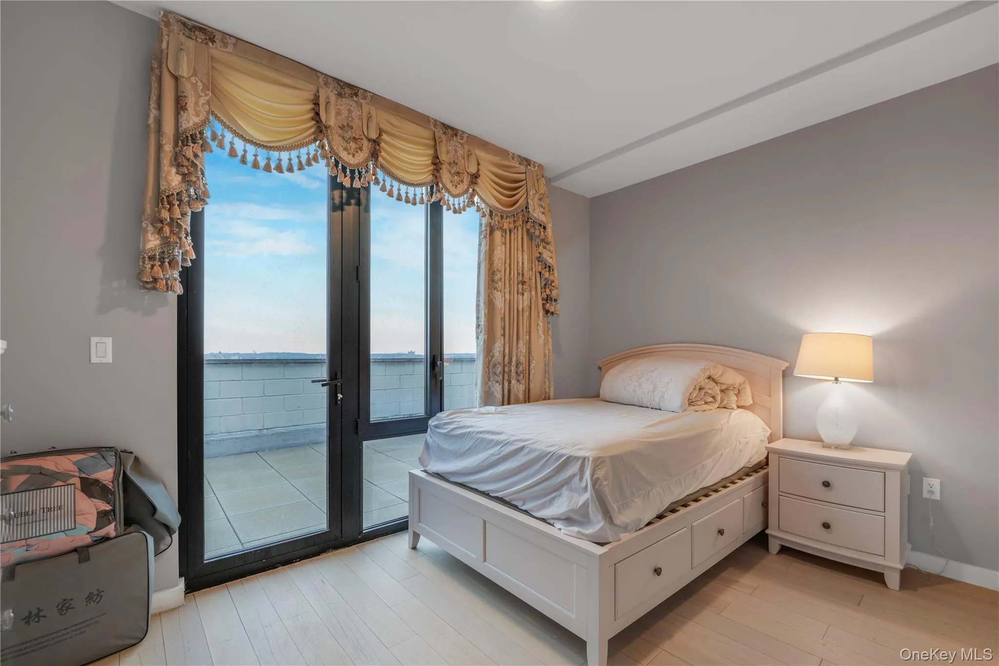 Bedroom with access to exterior, light wood-type flooring, and a water view Bedroom with access to exterior, light wood-type flooring, and a water view