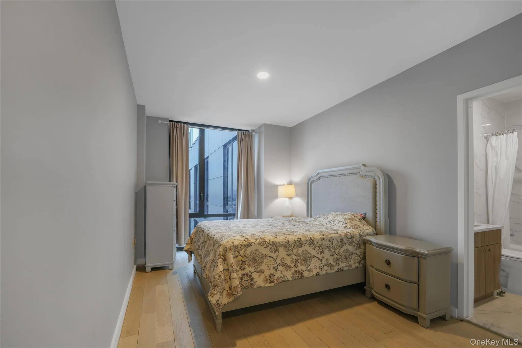 Bedroom with ensuite bath, light wood-style floors, and recessed lighting Bedroom with ensuite bath, light wood-style floors, and recessed lighting