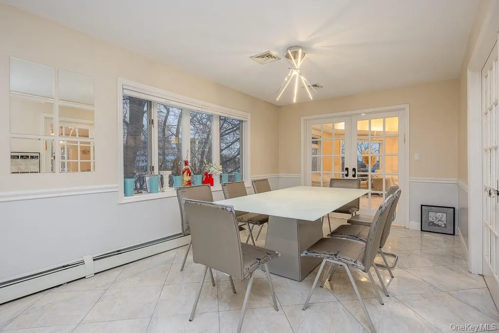 Dining area with french doors and a baseboard heating unit Dining area with french doors and a baseboard heating unit