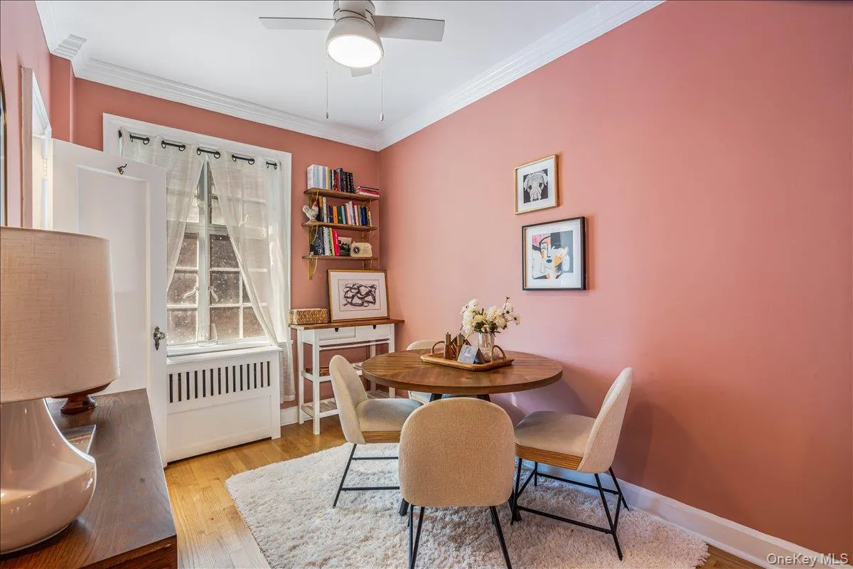 Dining space featuring radiator heating unit, ornamental molding, light wood-style floors, and a ceiling fan Dining space featuring radiator heating unit, ornamental molding, light wood-style floors, and a ceiling fan