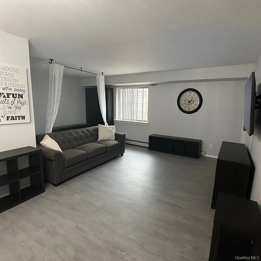 Living room with baseboard heating and light wood-style flooring Living room with baseboard heating and light wood-style flooring