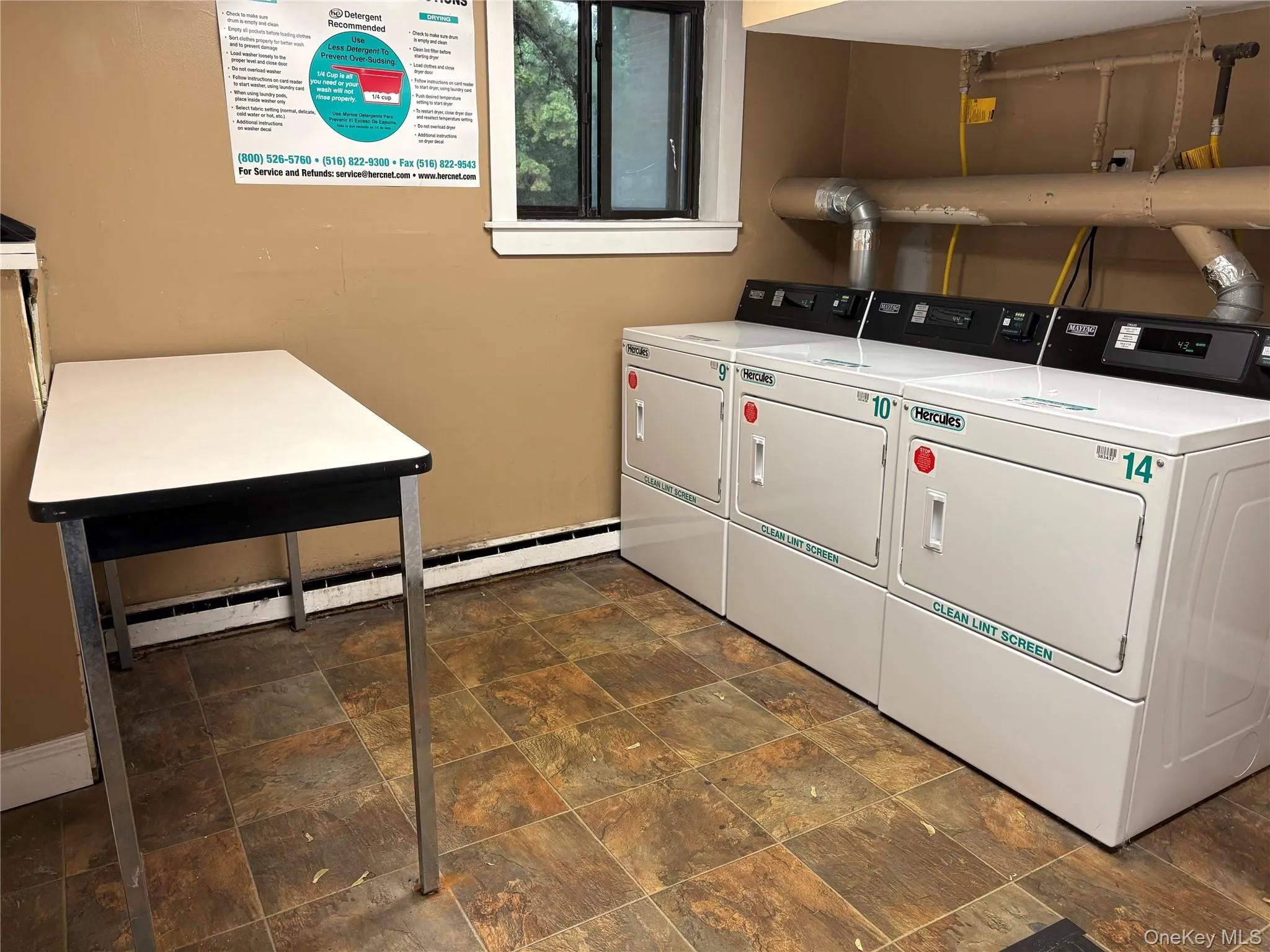 Communal laundry room with a baseboard radiator and washing machine and clothes dryer Communal laundry room with a baseboard radiator and washing machine and clothes dryer