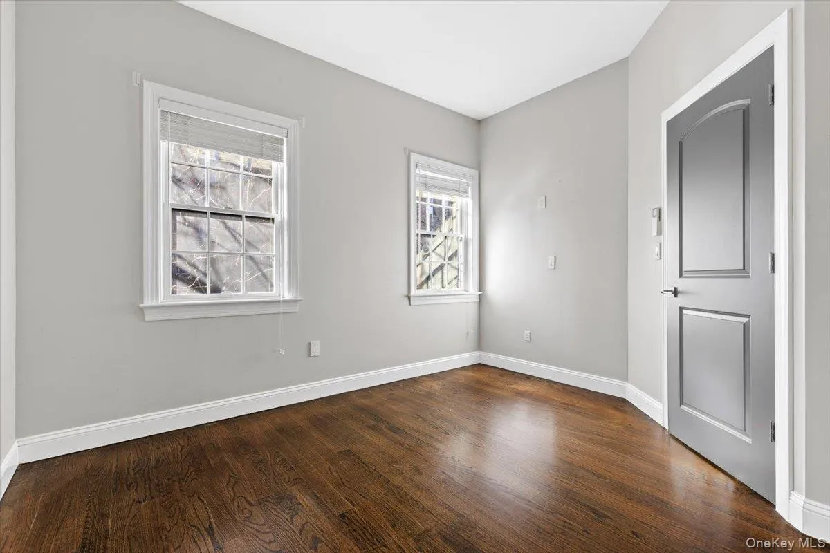 Unfurnished bedroom with baseboards and dark wood-style flooring Unfurnished bedroom with baseboards and dark wood-style flooring