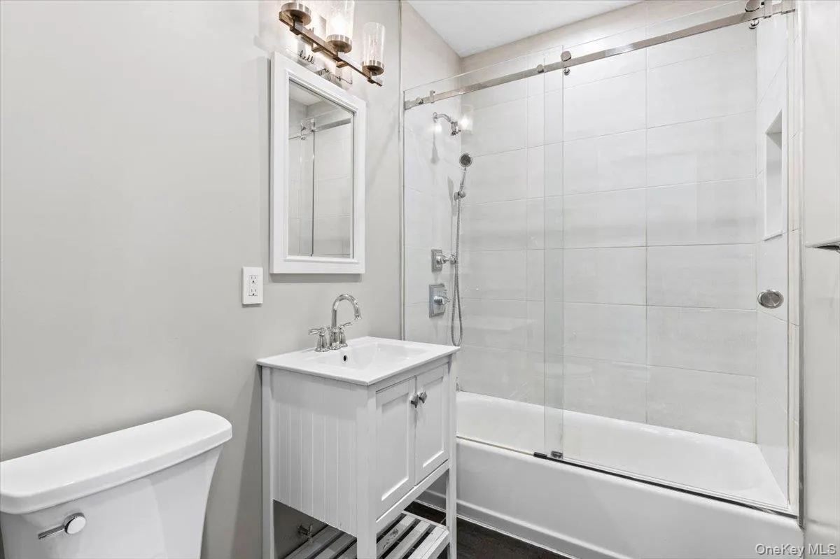 Full bathroom featuring vanity and shower / bath combination with glass door Full bathroom featuring vanity and shower / bath combination with glass door