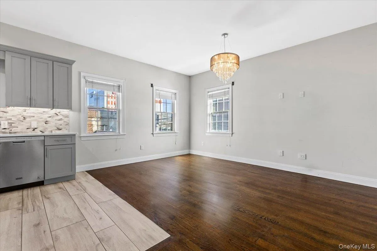 Unfurnished dining area with dark wood-type flooring and a chandelier Unfurnished dining area with dark wood-type flooring and a chandelier