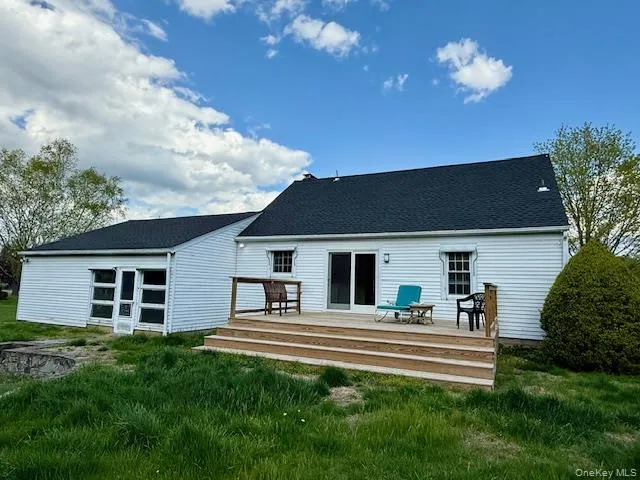 Back of property featuring a lawn and a wooden deck Back of property featuring a lawn and a wooden deck