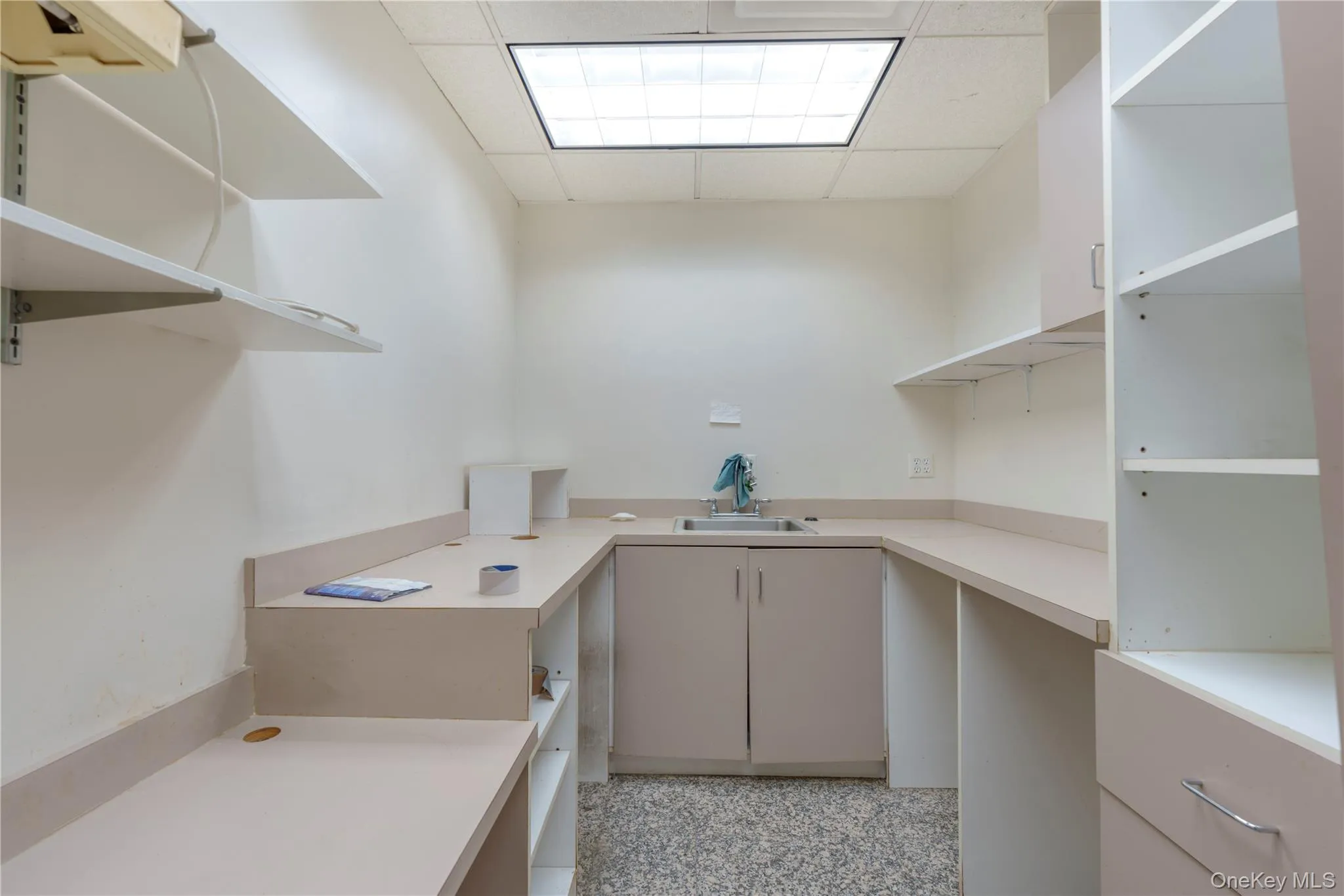 Laundry area featuring a drop ceiling and a sink Laundry area featuring a drop ceiling and a sink
