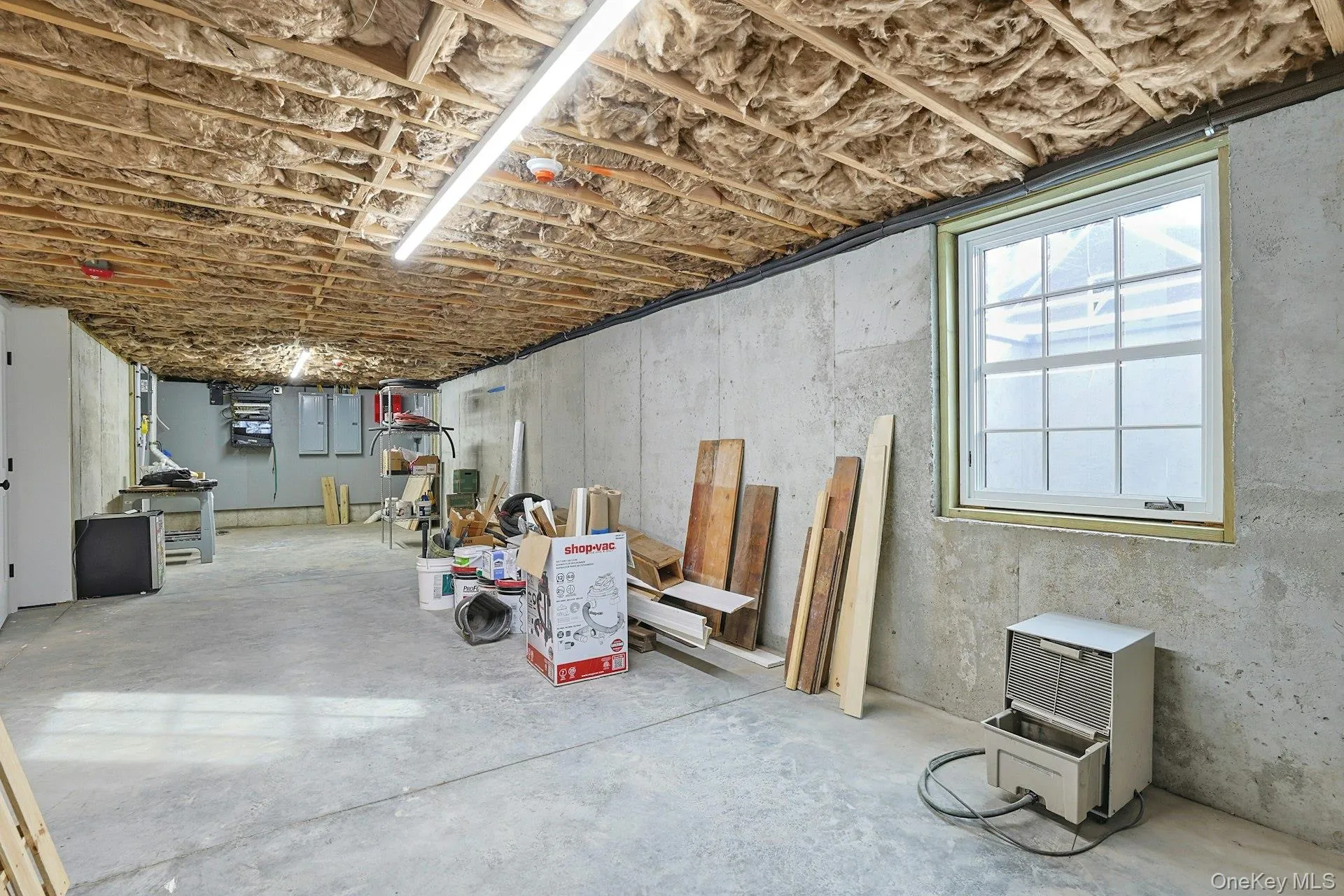 Basement with electric panel and refrigerator Basement with electric panel and refrigerator