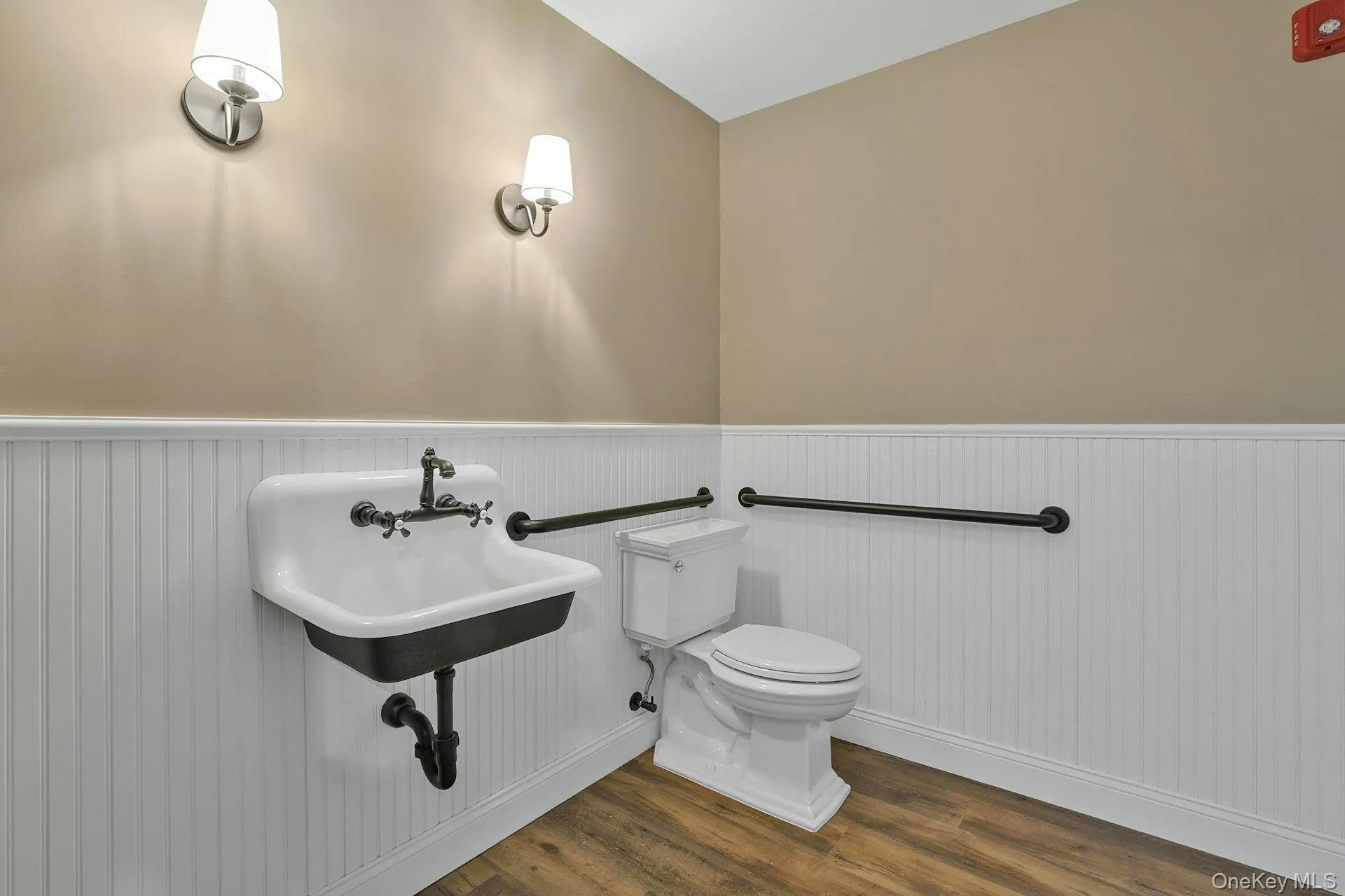 Bathroom with dark wood-type flooring and wainscoting Bathroom with dark wood-type flooring and wainscoting