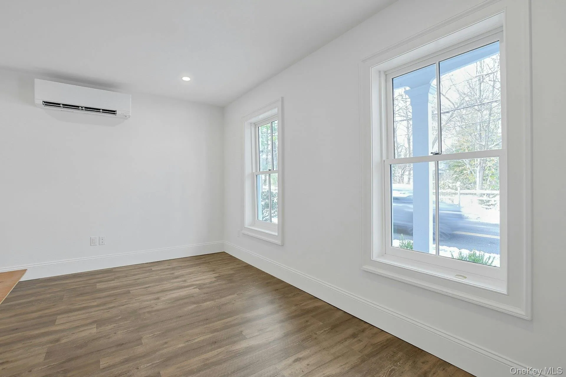 Spare room with wood finished floors, recessed lighting, and an AC wall unit Spare room with wood finished floors, recessed lighting, and an AC wall unit
