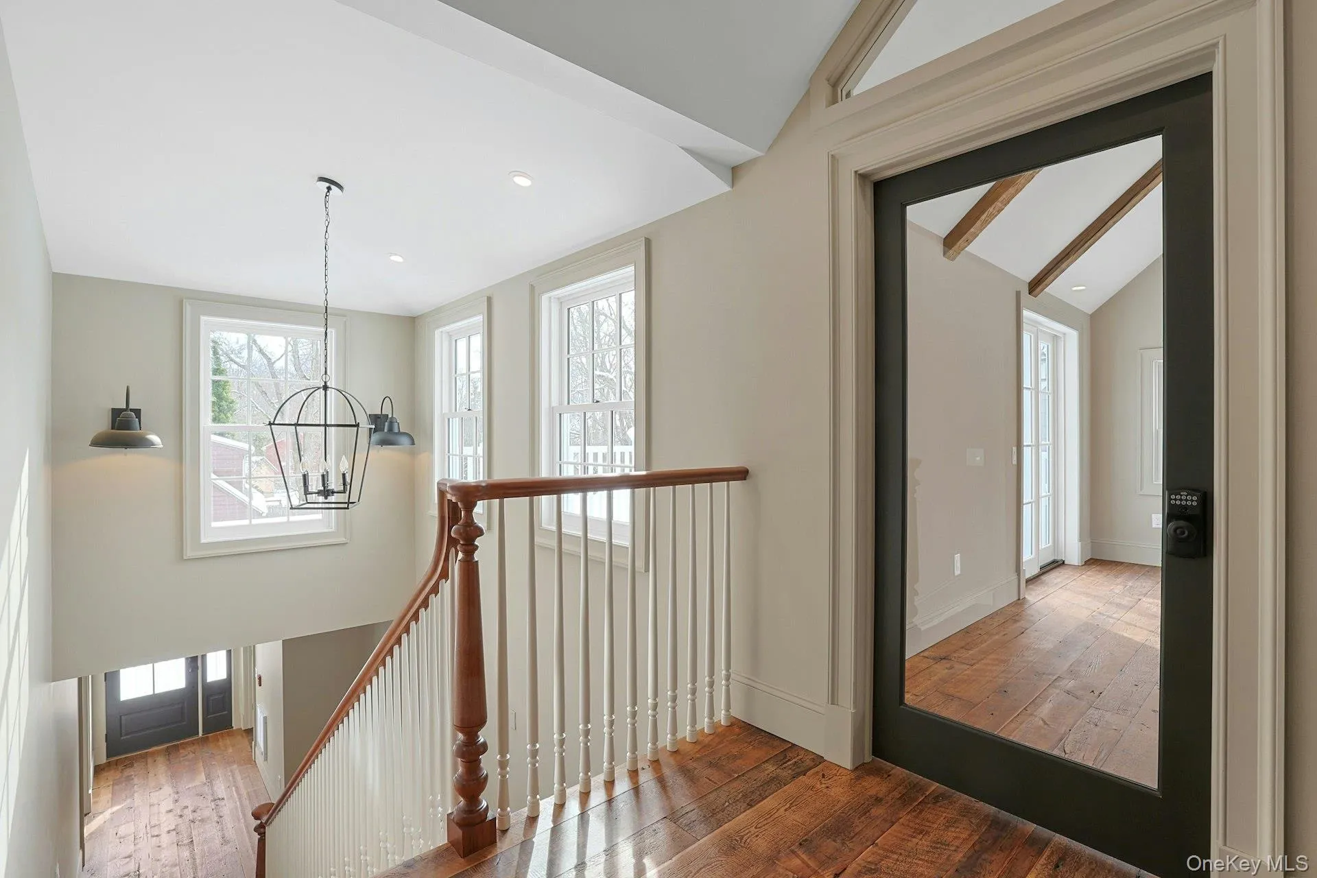 Staircase featuring hardwood / wood-style floors, a chandelier, and beamed ceiling Staircase featuring hardwood / wood-style floors, a chandelier, and beamed ceiling