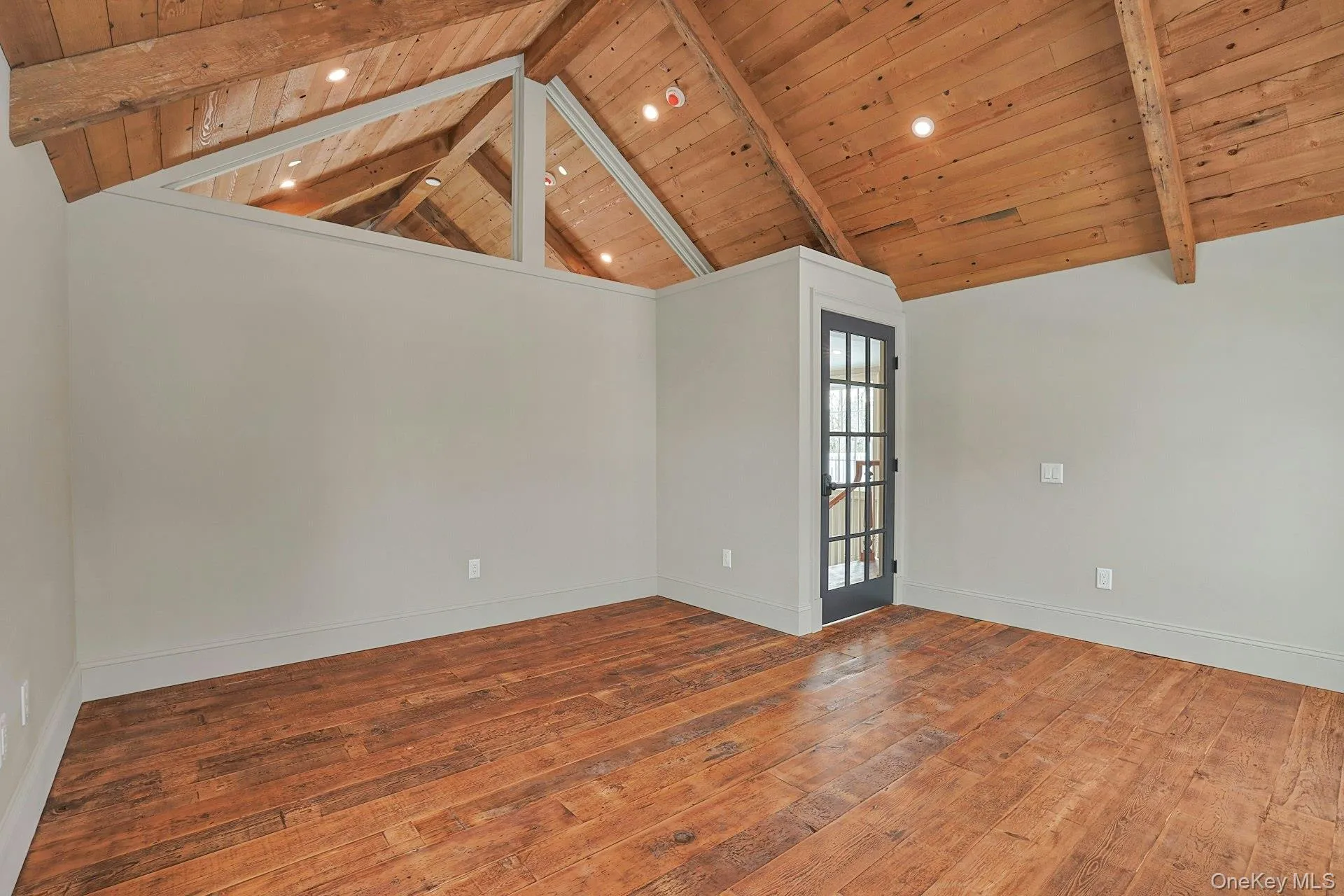Empty room featuring hardwood / wood-style flooring and wood ceiling Empty room featuring hardwood / wood-style flooring and wood ceiling