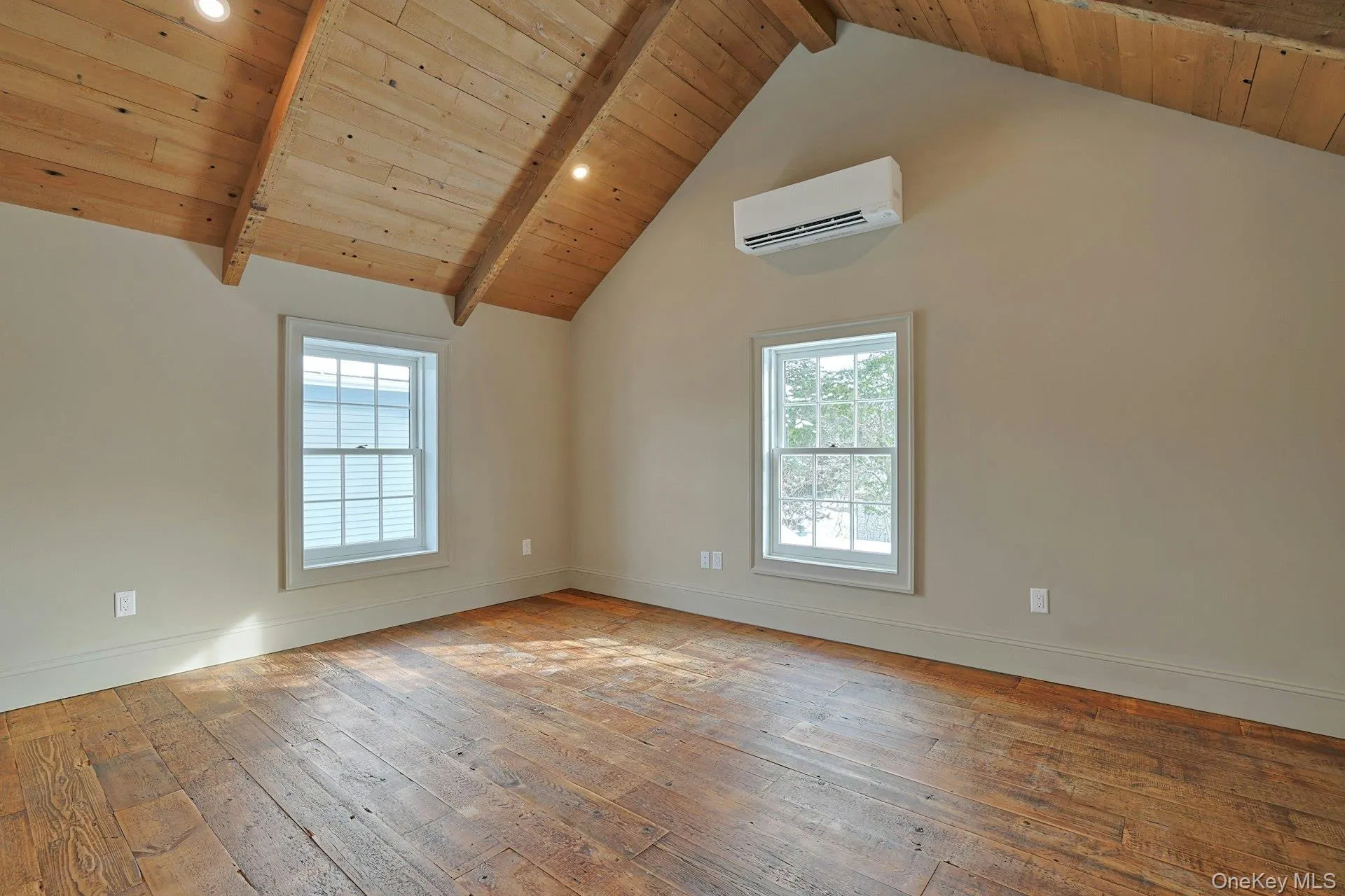 Empty room featuring light wood-type flooring, wooden ceiling, and a wall mounted AC Empty room featuring light wood-type flooring, wooden ceiling, and a wall mounted AC
