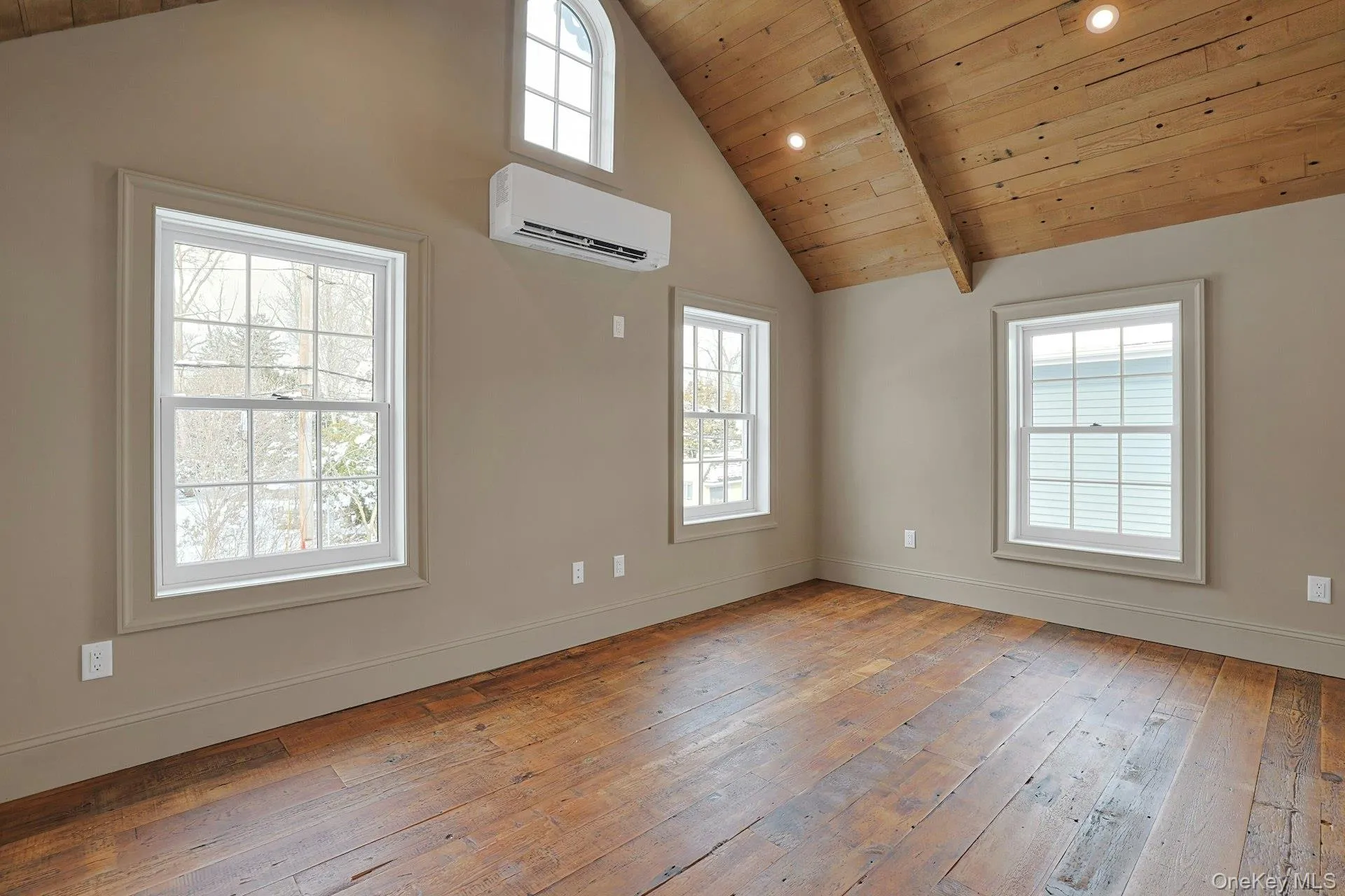 Unfurnished room with light wood-type flooring, a wooden ceiling with exposed beams, a wall mounted AC, plenty of natural light, and high vaulted ceiling Unfurnished room with light wood-type flooring, a wooden ceiling with exposed beams, a wall mounted AC, plenty of natural light, and high vaulted ceiling