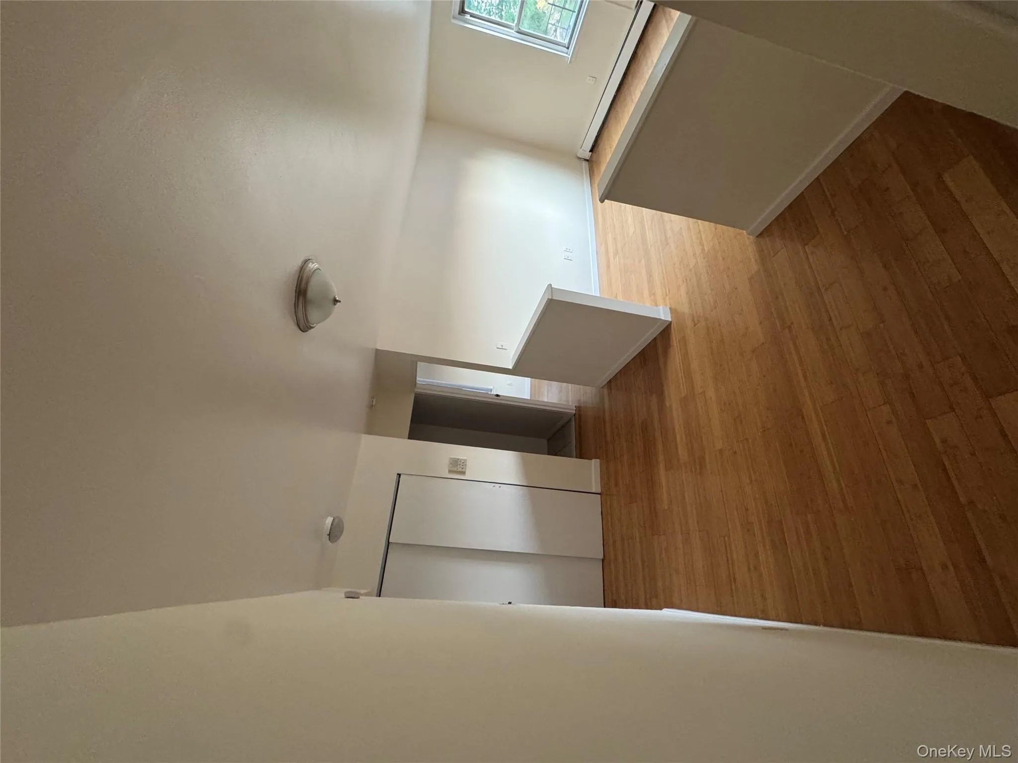 Corridor featuring a baseboard heating unit, an upstairs landing, and light wood finished floors Corridor featuring a baseboard heating unit, an upstairs landing, and light wood finished floors