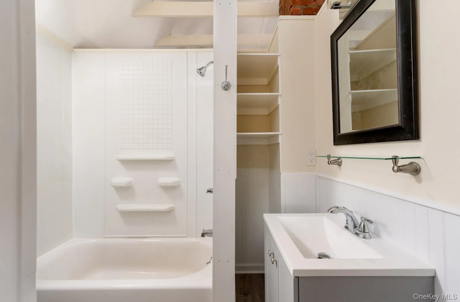 Full bathroom with wainscoting, vanity, shower / bathtub combination, and a decorative wall Full bathroom with wainscoting, vanity, shower / bathtub combination, and a decorative wall