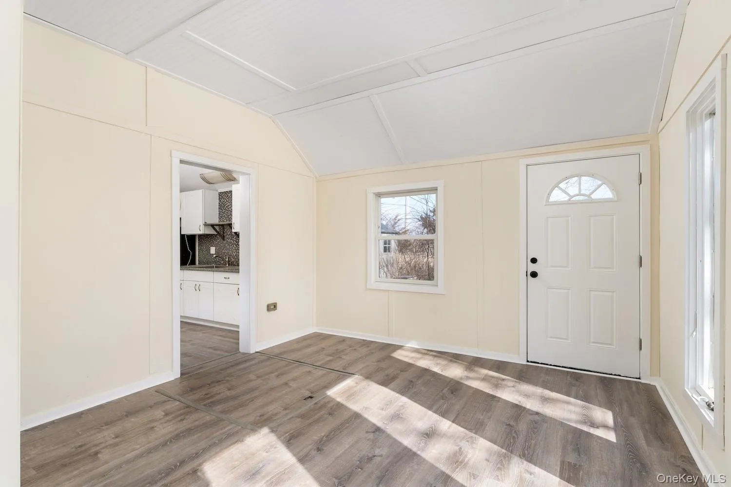 Foyer entrance featuring lofted ceiling and wood finished floors Foyer entrance featuring lofted ceiling and wood finished floors