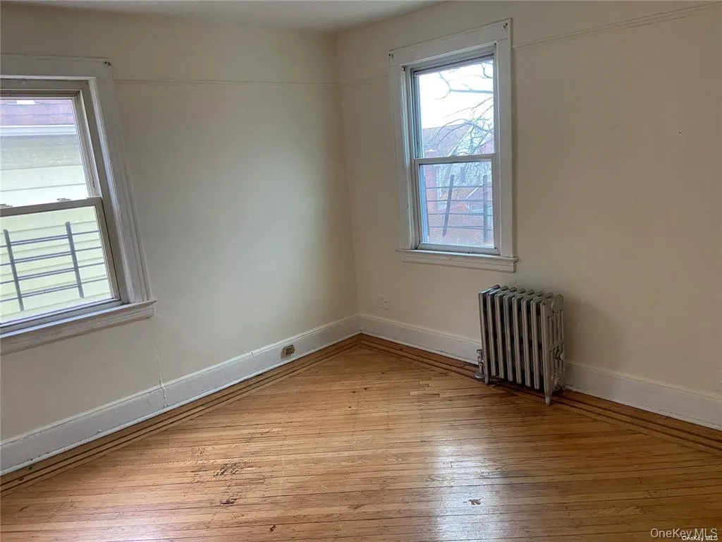 Unfurnished room with light wood-type flooring and radiator Unfurnished room with light wood-type flooring and radiator