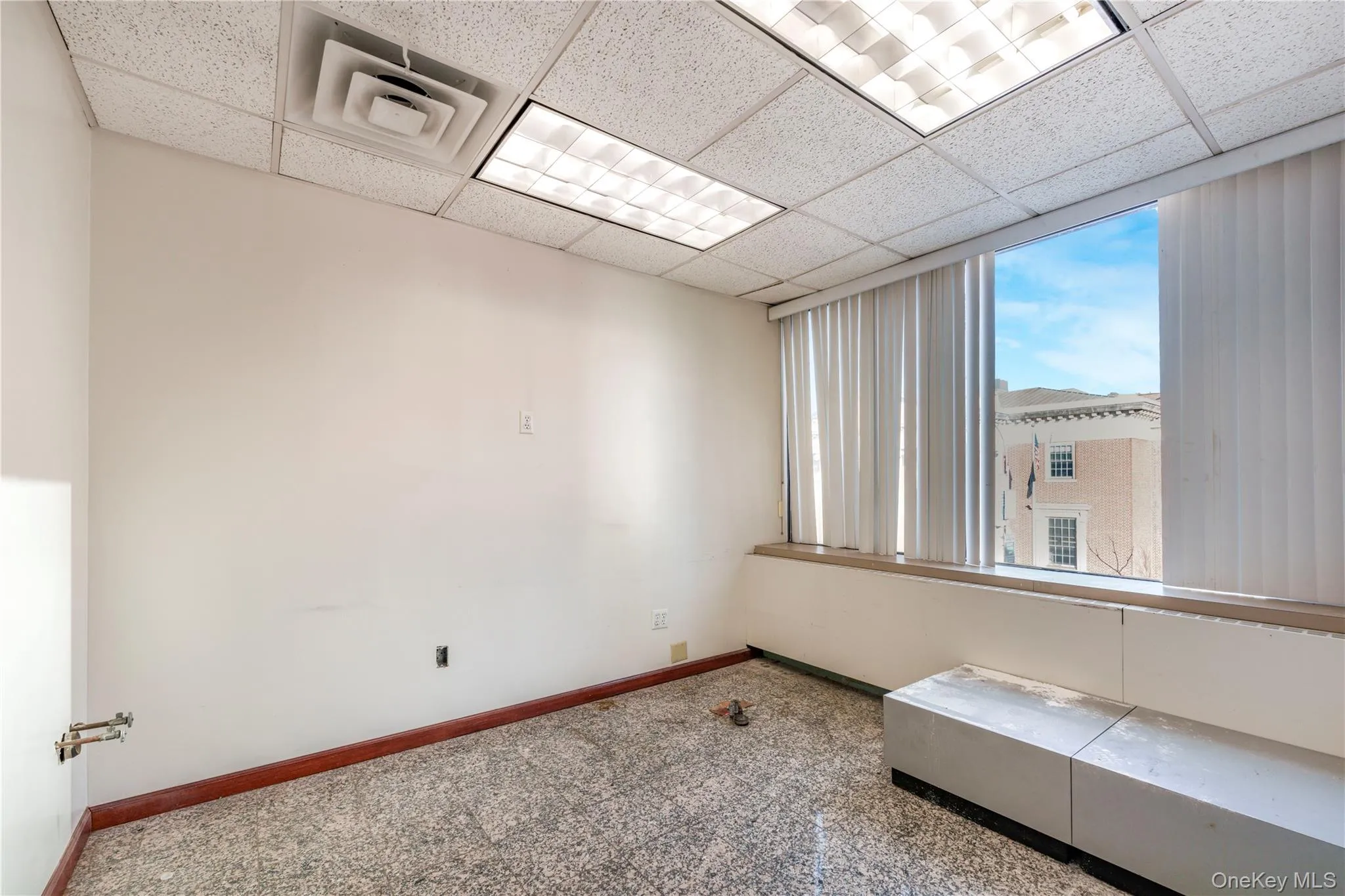 Spare room featuring granite tiled floors and a paneled ceiling Spare room featuring granite tiled floors and a paneled ceiling
