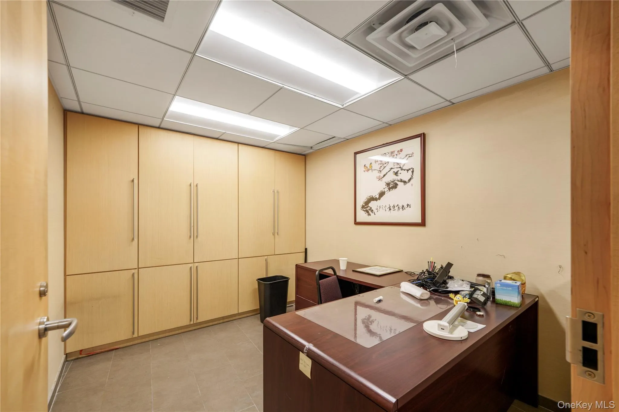 Office area with a paneled ceiling and light tile patterned floors Office area with a paneled ceiling and light tile patterned floors