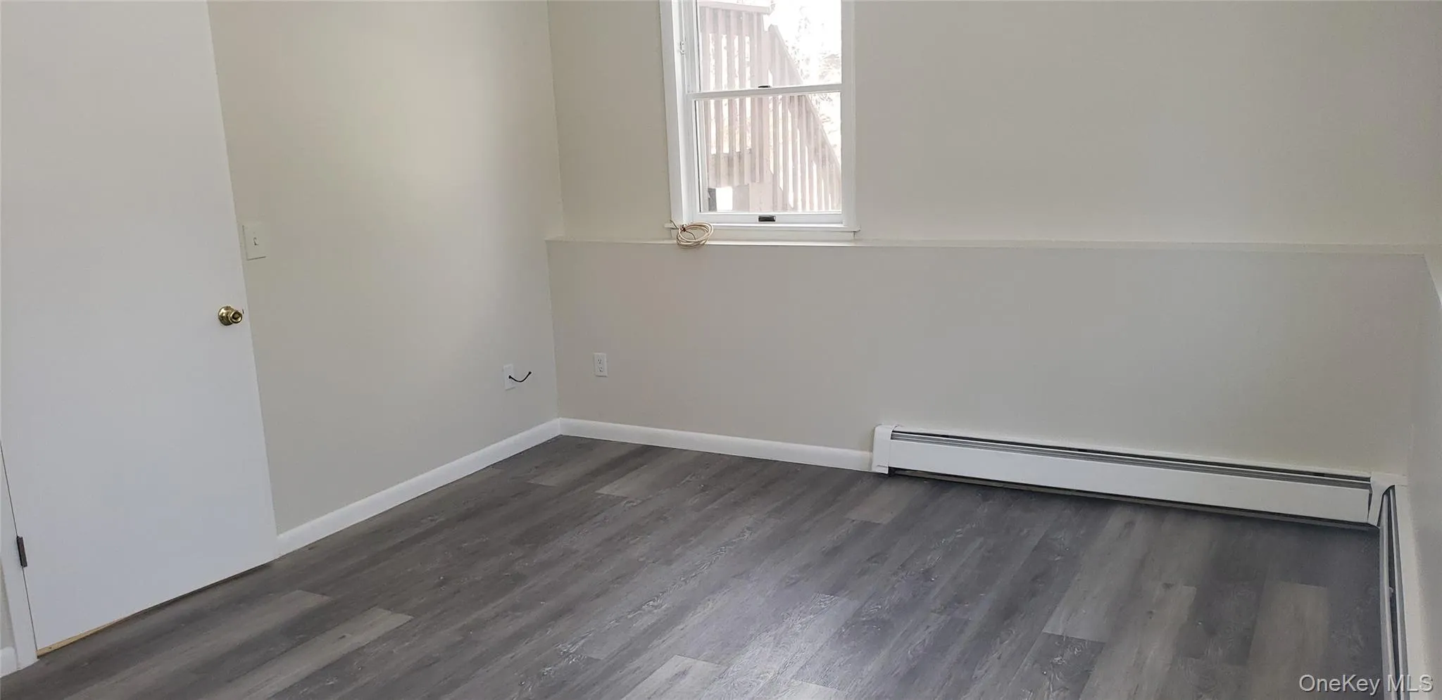 Unfurnished room featuring a baseboard heating unit, dark wood-type flooring, and a baseboard radiator Unfurnished room featuring a baseboard heating unit, dark wood-type flooring, and a baseboard radiator