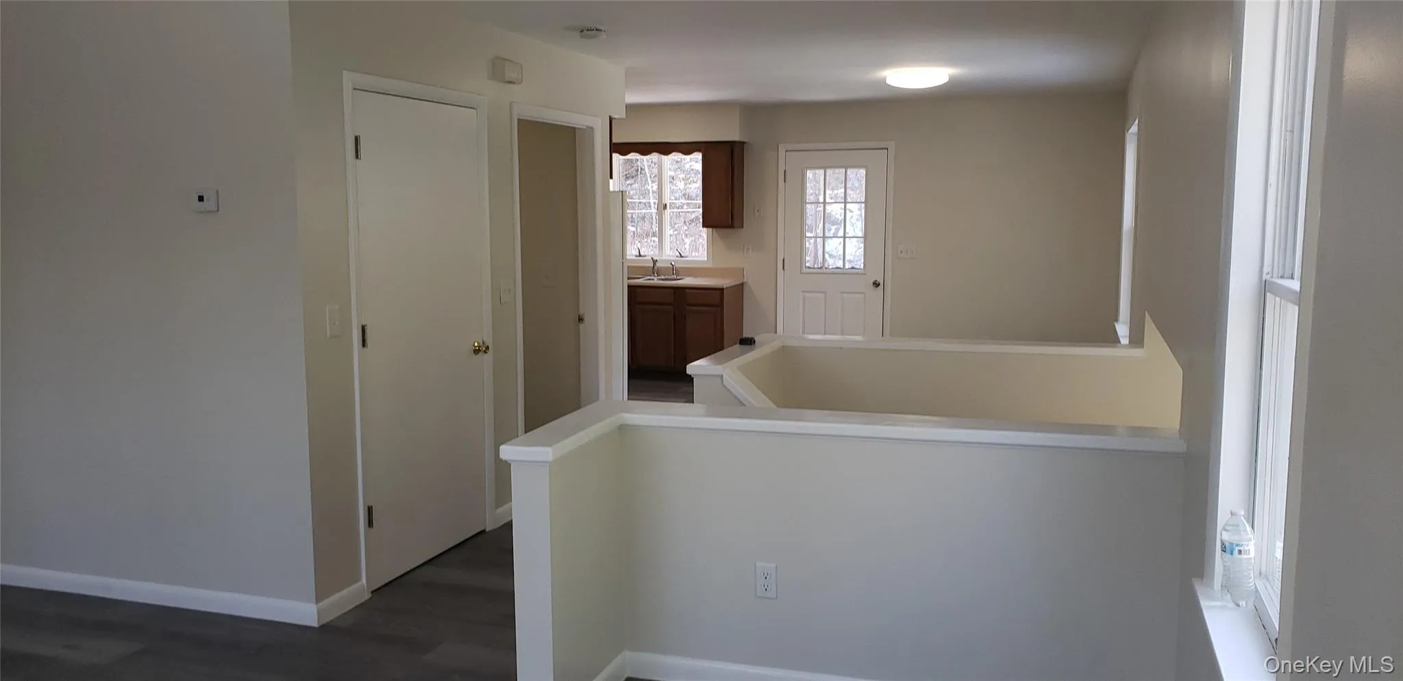 Laundry area with dark wood-style floors and baseboards Laundry area with dark wood-style floors and baseboards