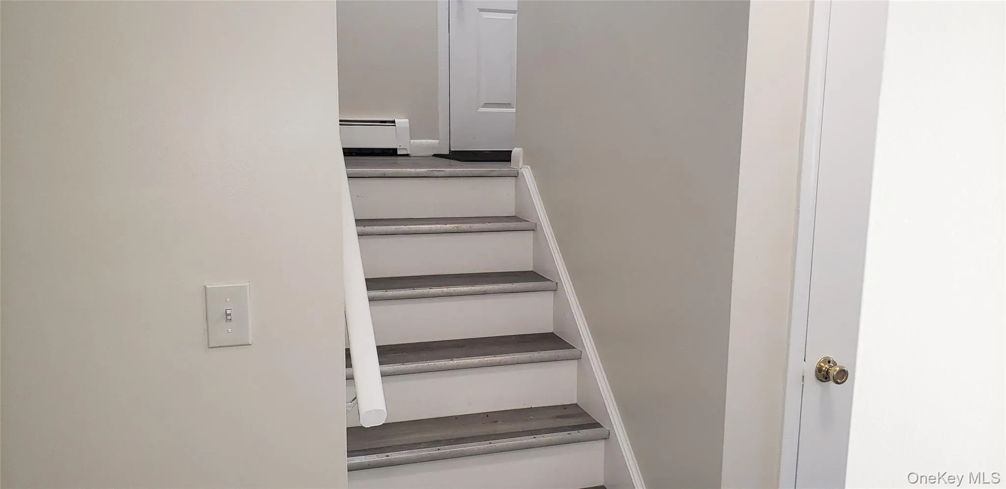 Stairway with a baseboard heating unit Stairway with a baseboard heating unit