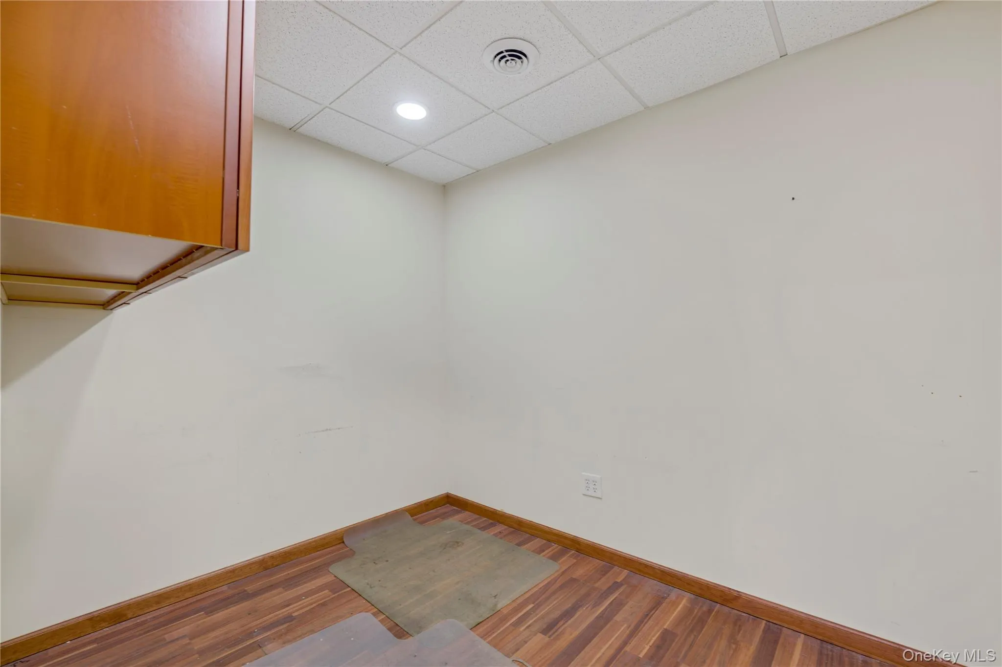 Unfurnished room with a paneled ceiling, wood finished floors, and recessed lighting Unfurnished room with a paneled ceiling, wood finished floors, and recessed lighting