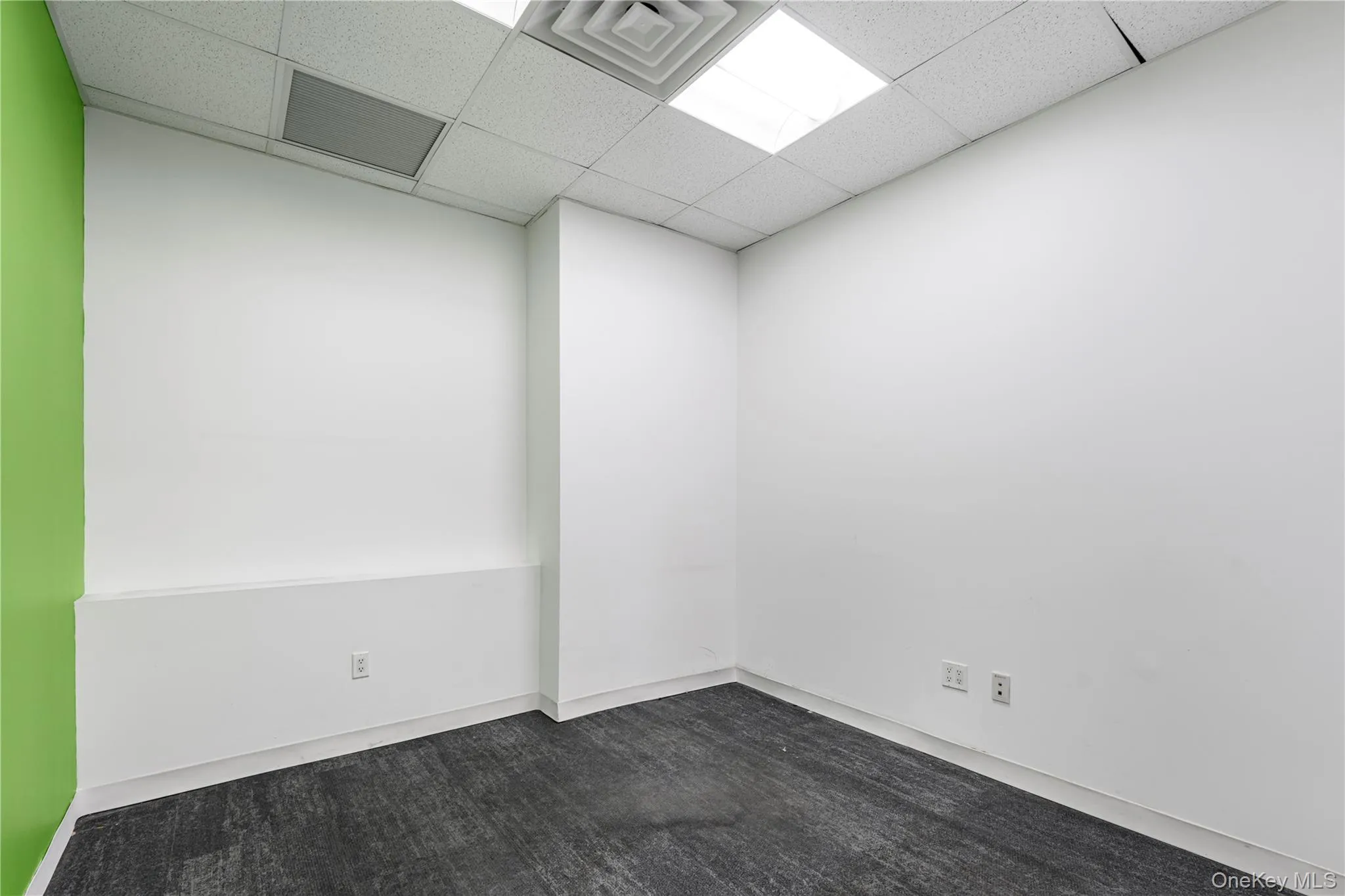 Unfurnished room with a drop ceiling and dark carpet Unfurnished room with a drop ceiling and dark carpet